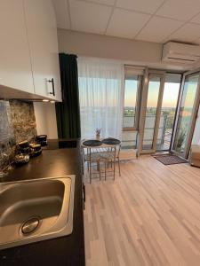 里加Krasta Home apartament Free Parking With CITY & RIVER VIEW的厨房配有水槽和桌椅