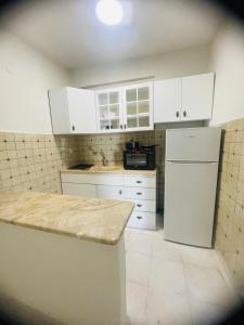 奥林匹亚基·阿克蒂ΑKASTI STUDIOS的厨房配有白色橱柜和白色冰箱。