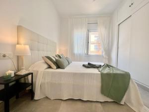 埃勒凡达尔Golden Coast Calafell的白色卧室设有一张带窗户的床