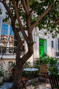 圣地亚哥Yogi hostel boutique的绿门旁树边的桌椅