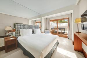 米乔尔海滩Gecko Hotel & Beach Club, a Small Luxury Hotel of the World的卧室设有一张白色大床和一扇窗户。