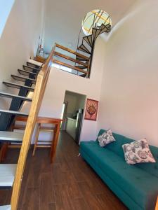 洛佩斯港Verano Azul Loft的客厅设有绿色沙发和楼梯。