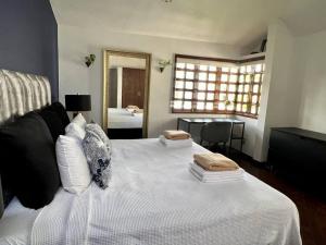 坎昆Beautiful Jungle House on a strategic location的卧室配有白色的床和两个枕头