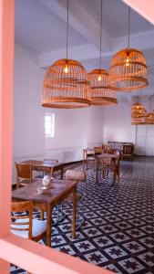 拉法尔达Holâ Hotel的用餐室配有桌椅和吊灯。