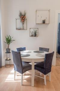 萨格勒布Magnolia apartment的餐桌、椅子和白色墙壁