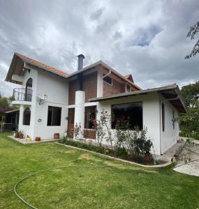 里奥班巴Casa de campo Guano Ecuador的前面有草坪的白色房子