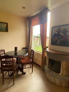里奥班巴Casa de campo Guano Ecuador的客厅配有桌子、电视和壁炉