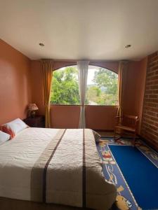 里奥班巴Casa de campo Guano Ecuador的一间卧室设有一张床和一个大窗户