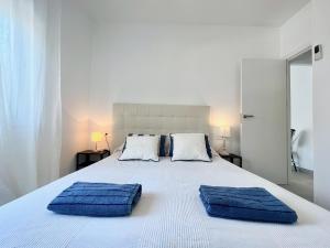 埃勒凡达尔GOLDEN COAST CALAFELL 2的一张带两个蓝色枕头的白色床