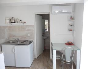 巴比诺波尔杰Apartments and rooms with parking space Sobra, Mljet - 18465的厨房配有水槽和桌椅