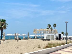 埃勒凡达尔GOLDEN COAST CALAFELL 2的海滩上设有白色的遮阳伞和海洋