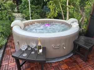 PieaCasale di Anna的热水浴池,配有一瓶葡萄酒和酒杯