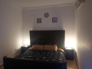 索瓦马A wonderful stay at the Dead Sea的一张黑色的床,房间有两个灯