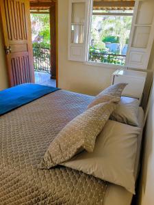 米格尔-佩雷拉Villa Terracotta的一间卧室配有一张带枕头和窗户的床