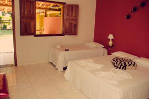 InhaúmaHotel Fazenda Coninho的一间设有两张床的客房和墙上的镜子