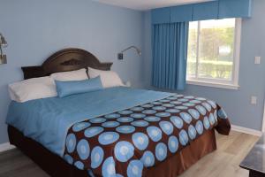 Hitching Post Motel的一间卧室设有一张带蓝色墙壁和窗户的大床