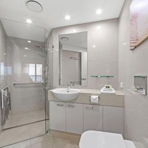 阳光海岸哥斯达新星假日公寓的白色的浴室设有水槽和淋浴。