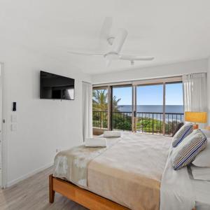 阳光海岸哥斯达新星假日公寓的白色的卧室设有床和大窗户