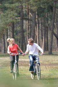 布克洛巴德布克洛度假酒店的公园里骑着自行车的男人和女人