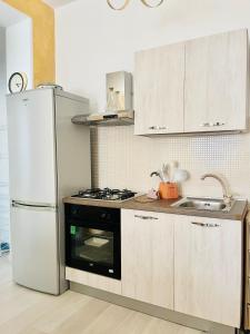 斯卡莱阿Minù house的厨房配有白色冰箱和水槽
