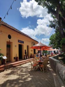 蒙波斯HOTEL NIETO MOMPOX, ubicado en el corazón del centro histórico, frente al rio magdalena en zona de malecón的一个带桌椅和遮阳伞的户外庭院。