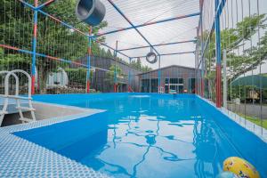 济州市济州最佳山上度假屋的一座空的游泳池,在建筑物里是蓝色的水