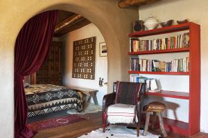 陶斯Casa Gallina - An Artisan Inn的一间卧室配有床和书架