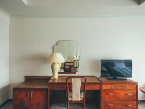 挂川市挂川大酒店的一张桌子,上面有一台电视和一盏灯