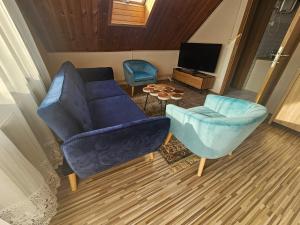 福纽德Judit's Guest House的客厅配有蓝色的沙发和两把椅子