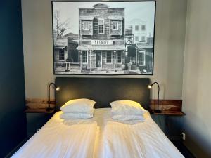 卡尔斯克鲁纳Hotell Siesta的一张带两个枕头的床和一幅房子的照片