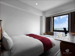 山形市Daiwa Roynet Hotel Yamagata Ekimae的酒店客房设有一张床和一个大窗户