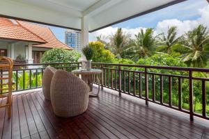 岘港Luxury Danatrip Villas的阳台配有桌椅和树木