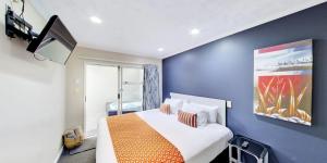 罗托鲁瓦Capri on Fenton的一间卧室配有一张带橙色毯子的大床