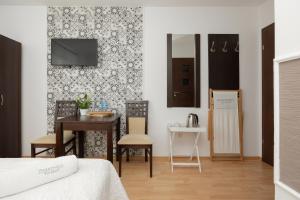 波别罗沃Zwierzyńscy Residence的卧室配有一张床和一张桌子及椅子