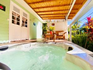 勒迪亚芒Villa Gaïa - Bungalow Ti-Zen et son jacuzzi niché dans un jardin tropical, séjour en amoureux的房屋庭院的热水浴池