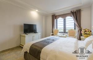 海防丹安宫公寓式酒店的一间卧室配有一张大床和一台平面电视