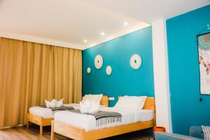 邦劳Holabay Resort的蓝色墙壁客房的两张床