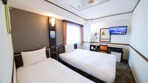富山东横INN-富山站新干线出口2的酒店客房配有两张床和一张书桌