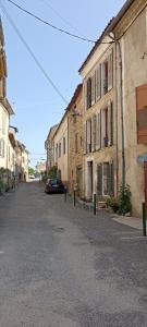 PuimoissonLa Maison de la Cloche的一条空的街道,在建筑物旁边停有一辆汽车