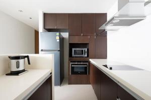 曼谷M Estate 2BR Private Residence, 300m to BTS Chit Lom的厨房配有白色台面和棕色橱柜