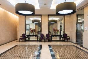 曼谷M Estate 2BR Private Residence, 300m to BTS Chit Lom的大堂设有一张长桌和紫色椅子