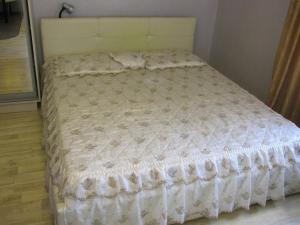 沃罗涅什Apartment Na Lenina 86A的卧室内的一张带白色棉被的床