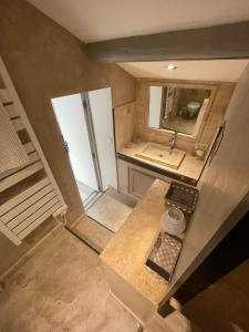 圣雷米普罗旺斯Appartement cosy plein de charme的厨房的顶部景观,配有水槽和镜子