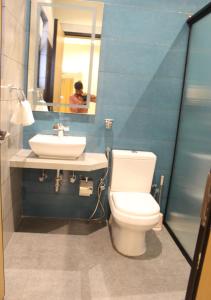 金沙萨Ixoras Hotel Lemba的一间带卫生间、水槽和镜子的浴室