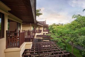 景洪市西双版纳安纳塔拉度假酒店的一个带木楼梯的房屋的阳台