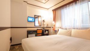 大阪Toyoko Inn Shin-Osaka Chuo-guchi Honkan的酒店客房设有白色的床和窗户。