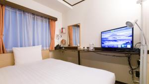 大阪Toyoko Inn Shin-Osaka Chuo-guchi Honkan的配有一张床和一台平面电视的酒店客房