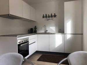 费尔德基希Apartments "Am Ardetzenberg"的厨房配有白色橱柜、水槽和炉灶。