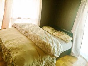 鸣门市オーベルジュ鳴門的卧室内的一张未铺好的床,设有窗户