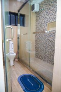 拉各斯MOBAK APARTMENT的带淋浴、卫生间和蓝色地毯的浴室